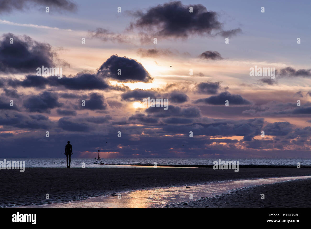 Iron Men statues on Crosby beach near Liverpool at sunset Stock Photo