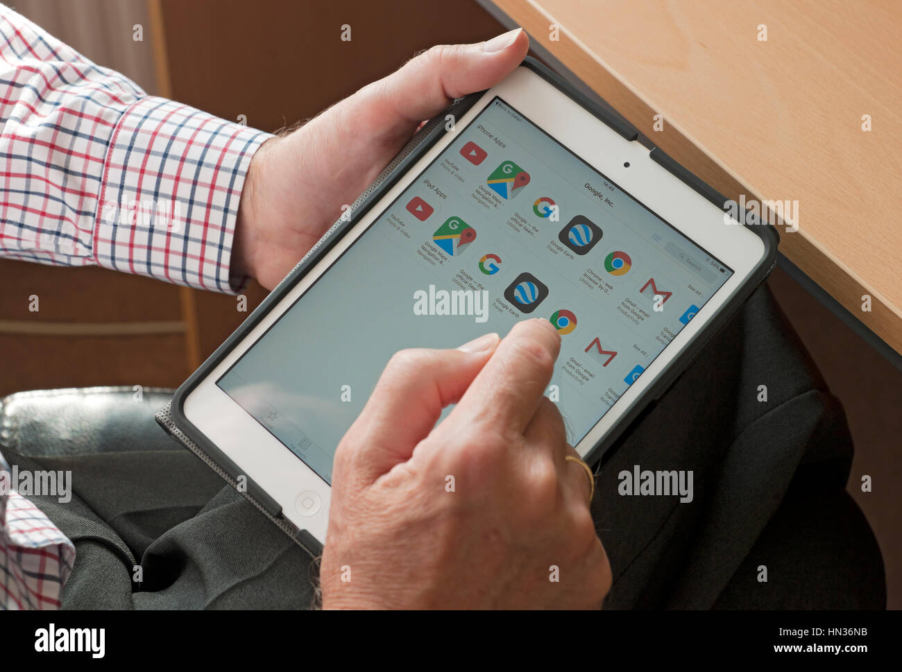 Man looking at Google apps on tablet . Stock Photo