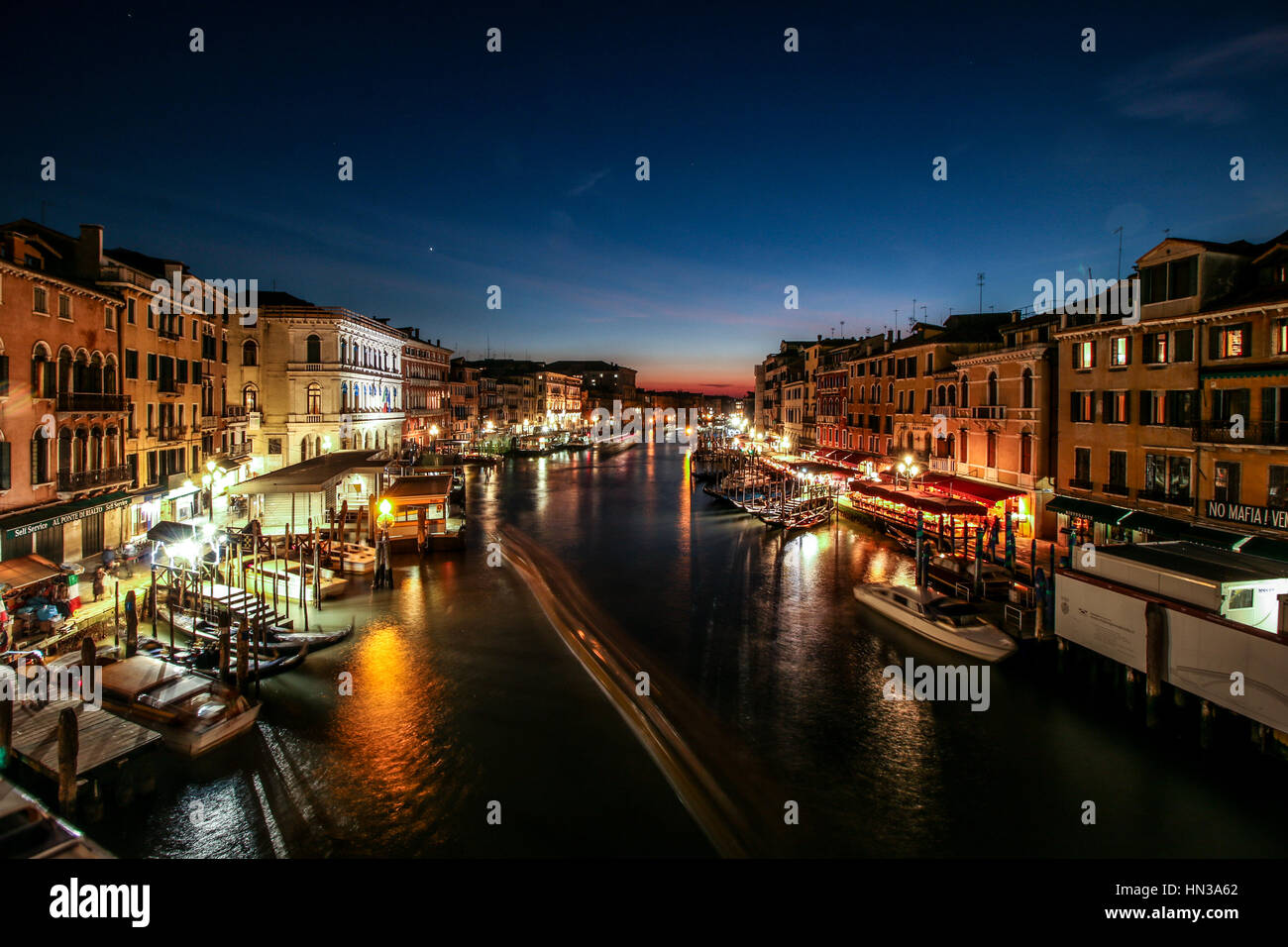 Sunset from the Rialto Bridge Venice Italy, long exposure, showing boats and people Stock Photo
