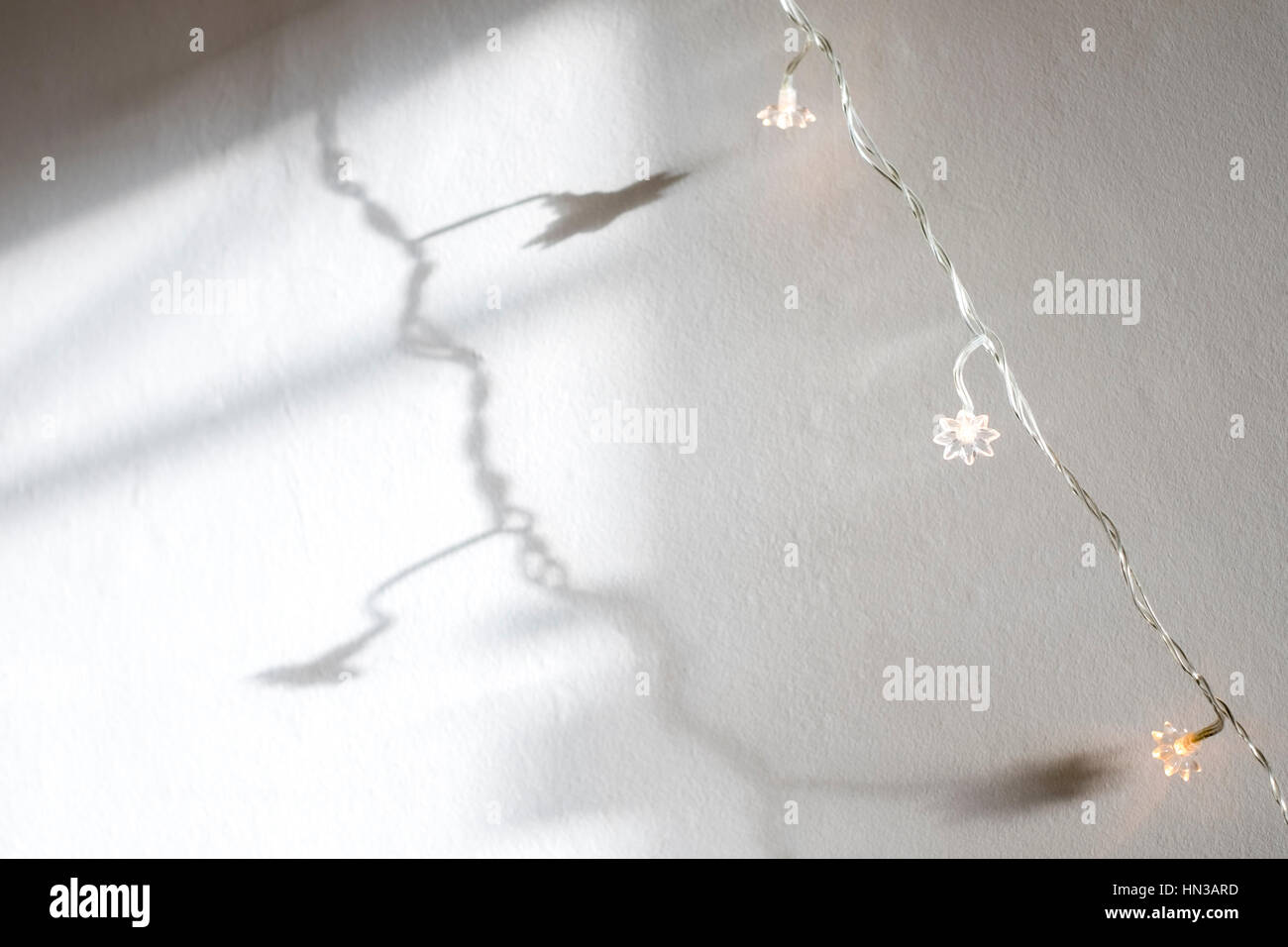 Christmas fairy lights reflected on white painted wall Stock Photo