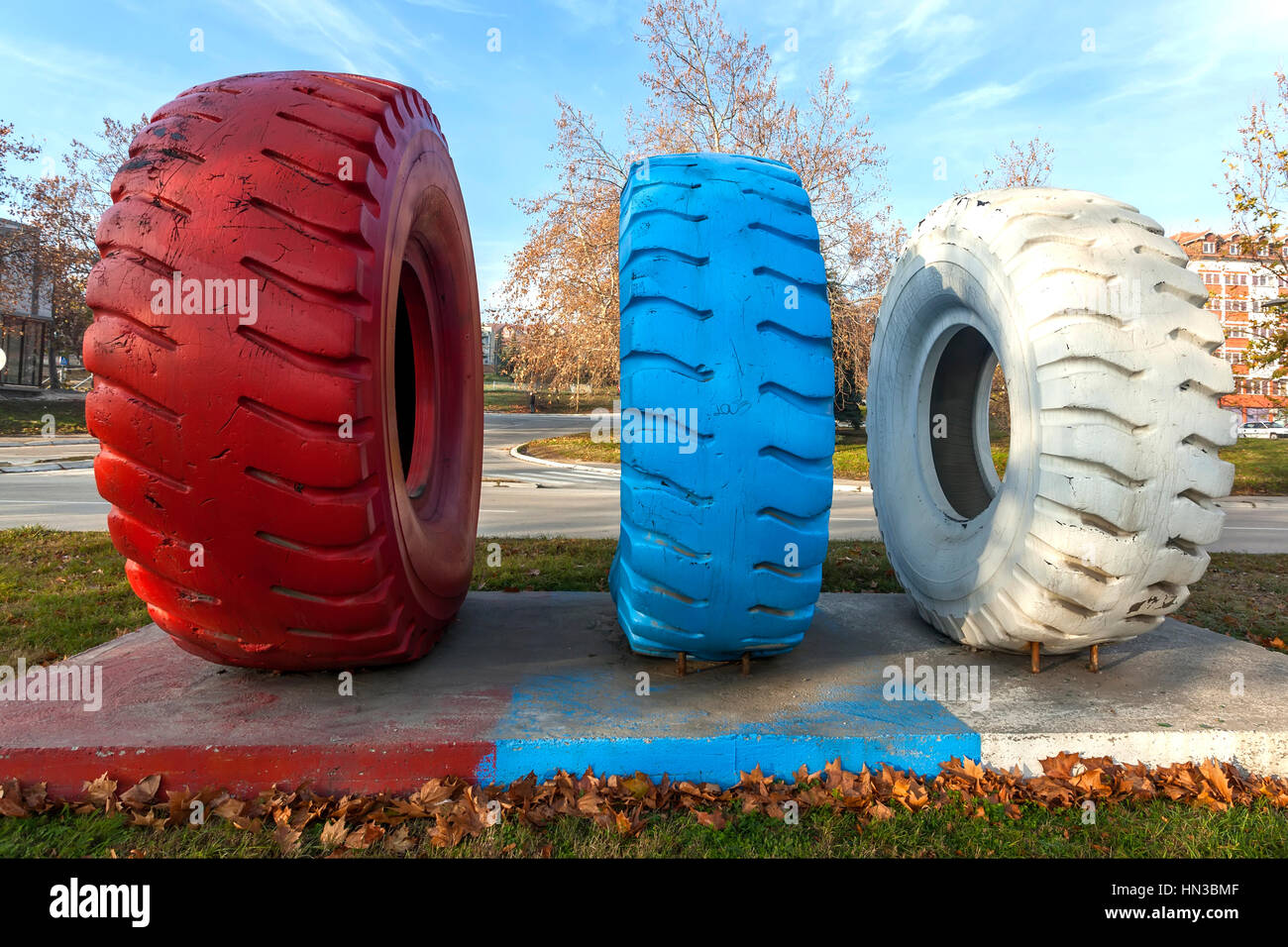 Dumper truck tires of different sizes placed as a monument in the industrial city Stock Photo