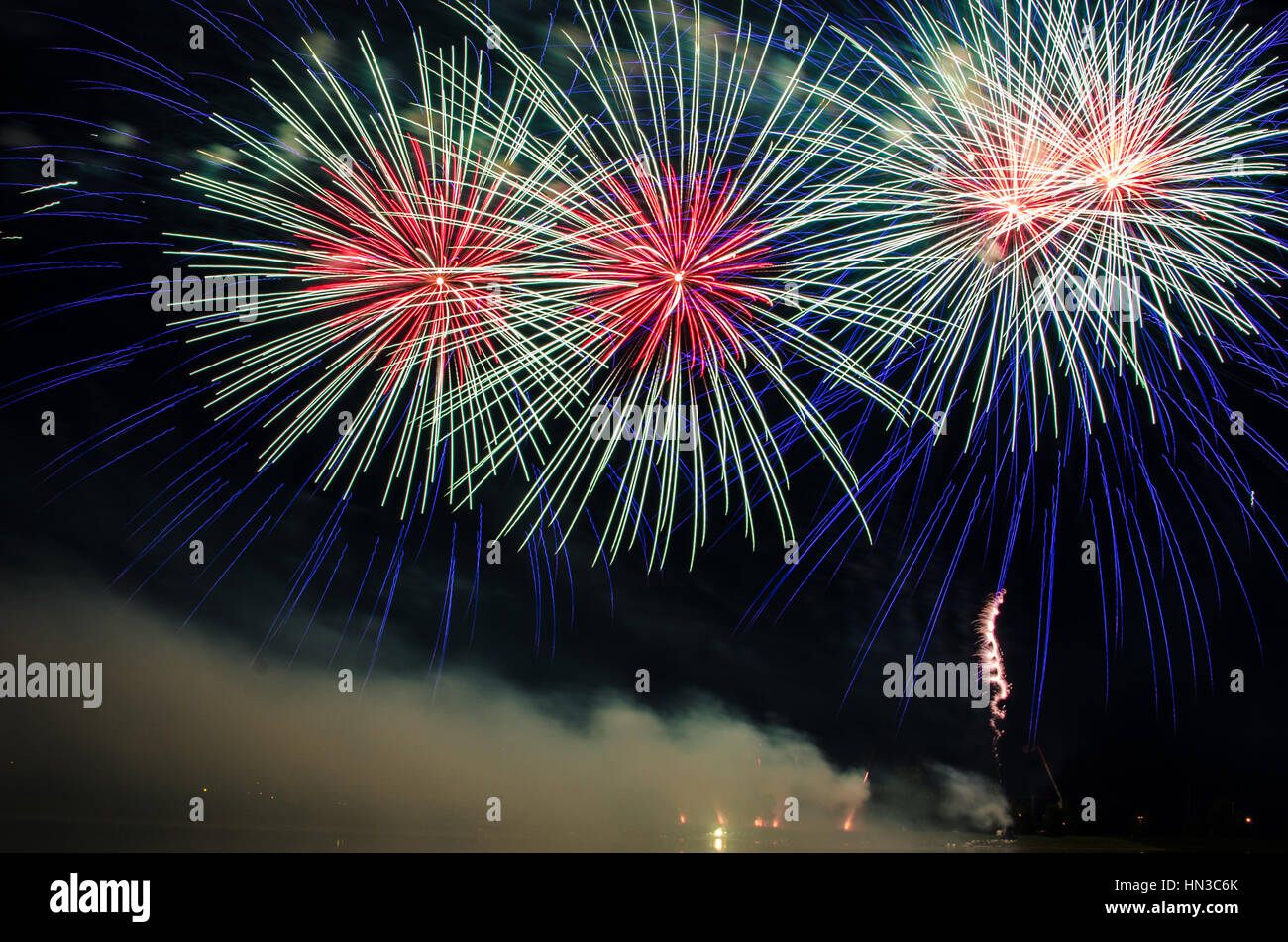 Fireworks display bursts at night Stock Photo