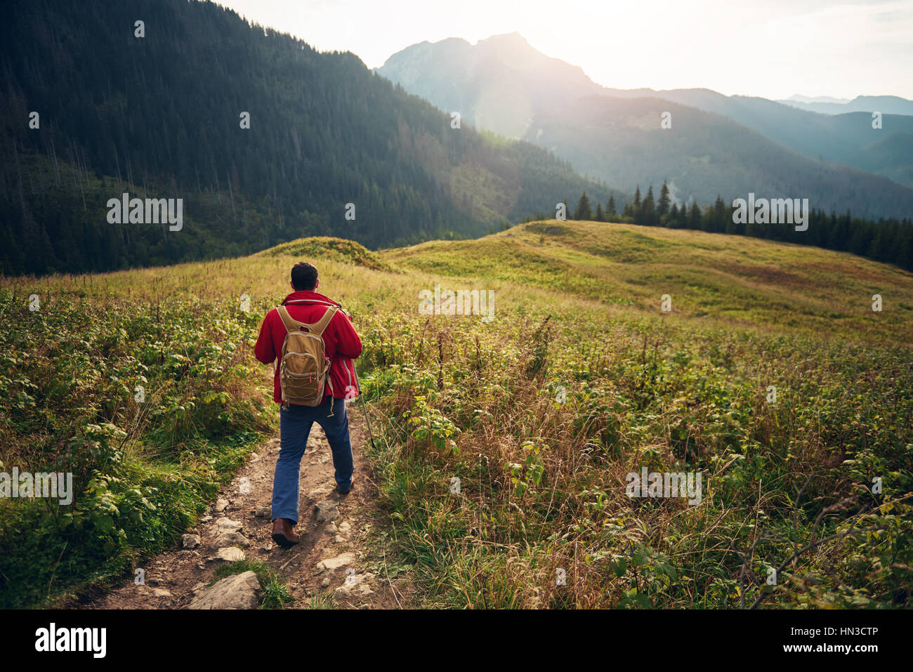 Young man walking backpack hi-res stock photography and images - Alamy