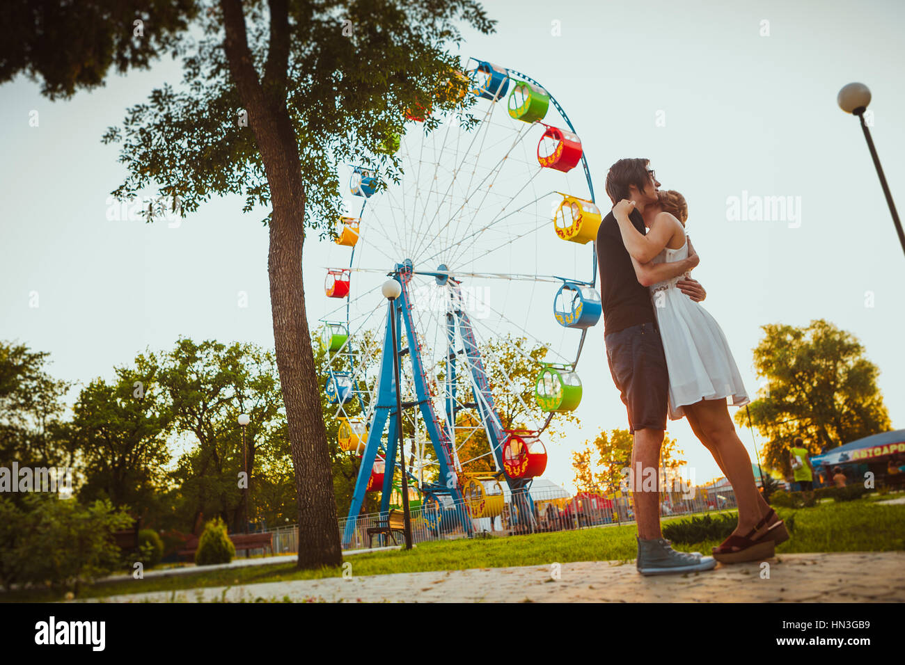 guy and the girl hugging at amusement background Stock Photo - Alamy