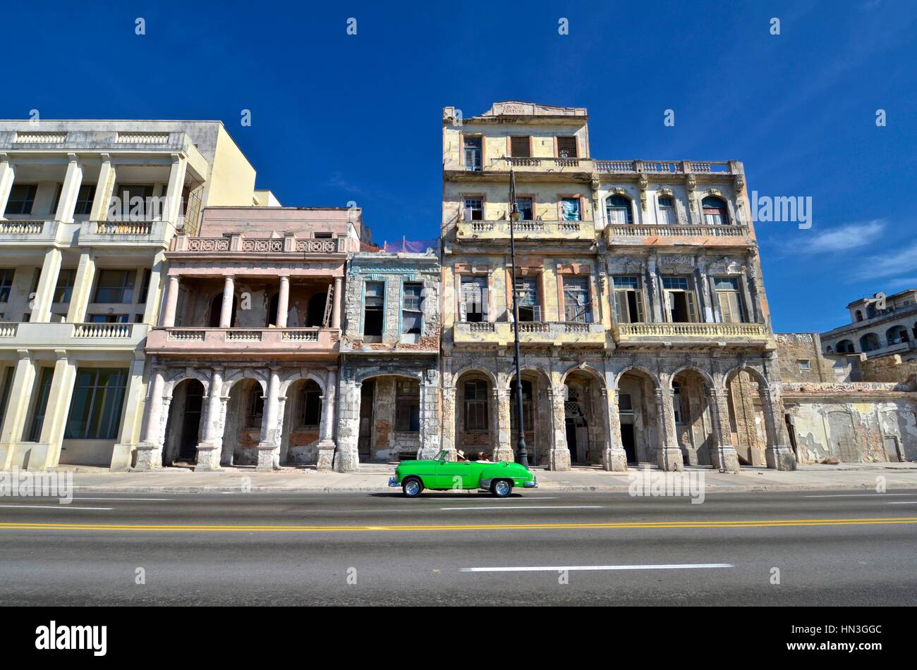 Old American vintage car passing by an abandoned building in El Malecon,  Havana Stock Photo - Alamy