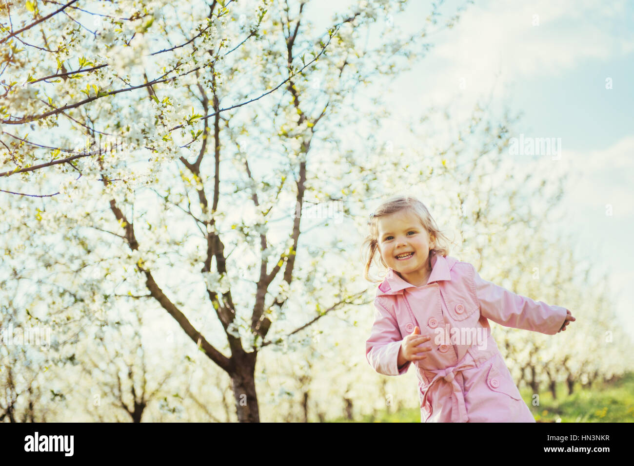 child running outdoors blossom trees. Art processing and retouch Stock Photo