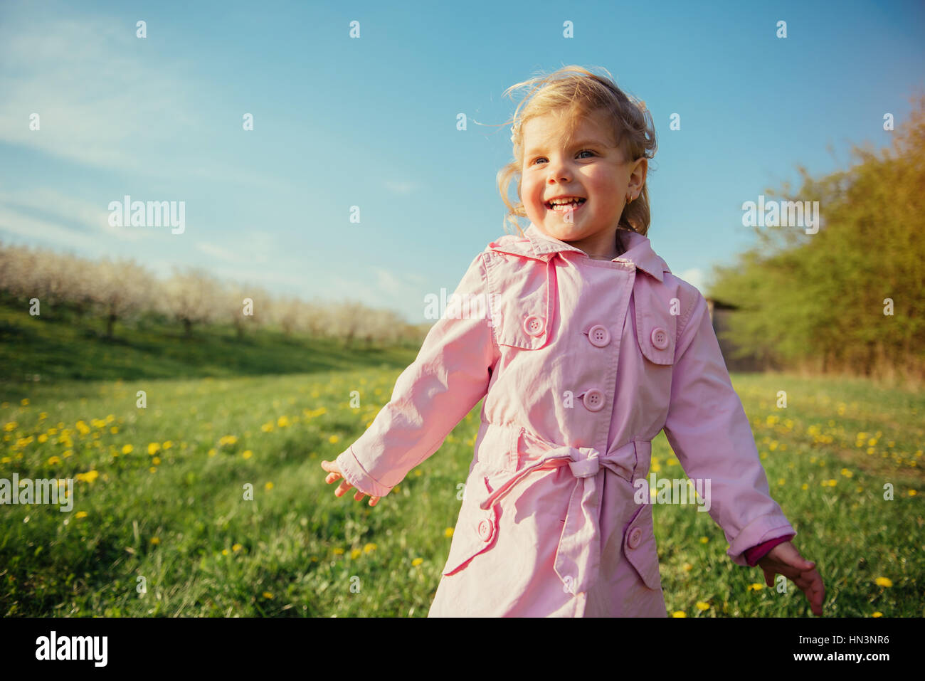 child plays on spring lawn. Stock Photo