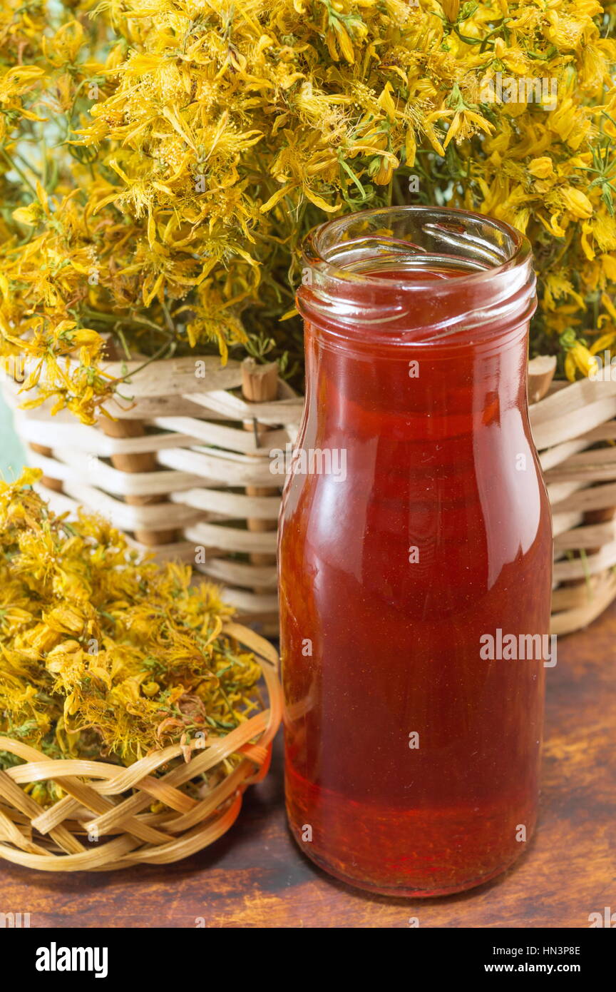 Saint Johns wort oil in a bottle and dried flowers Stock Photo