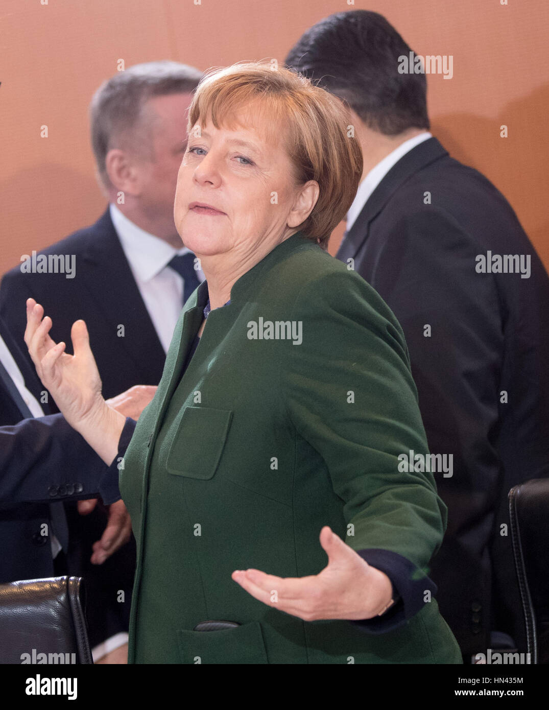 Berlin, Germany. 8th Feb, 2017. German chanchellor Angela Merkel arrives for a federal cabinet meeting in the chancellery in Berlin, Germany, 8 February 2017. In the background foreign minister Sigmar Gabriel and minister of health Hermann Groehe talk. Photo: Kay Nietfeld/dpa/Alamy Live News Stock Photo