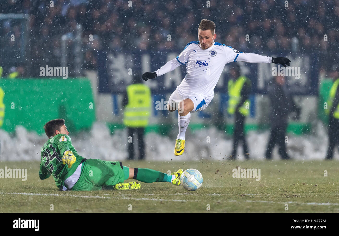 Lotte, Germany. 08th Feb, 2017. Kevin Freiberger (right) of Sportfreunde Lotte faces off against 1860 Munich goalkeeper Stefan Ortega on his way to a goal. Third division Lotte scored another upset for a 2-0 win Wednesday, putting them in the German Cup quarter-finals. Guido Kirchner/dpa Photo: Guido Kirchner/dpa/Alamy Live News Stock Photo