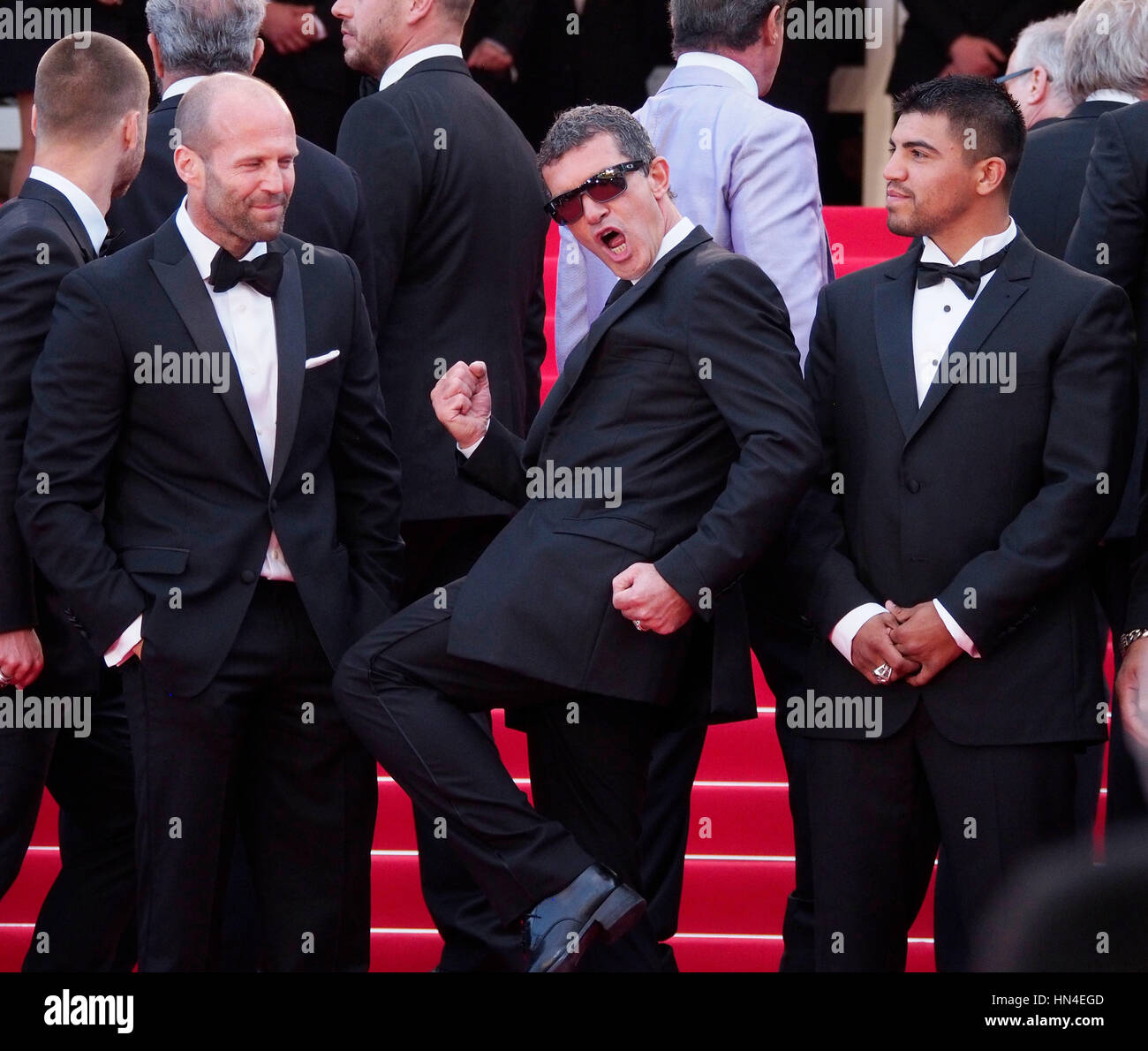 Antonio Banderas, kicks his leg up while Jason Stratham, left, and Victor Ortiz look on the red carpet at the Cannes Film Festival on May 18, 2014, in Cannes, France.  Photo by Francis Specker Stock Photo