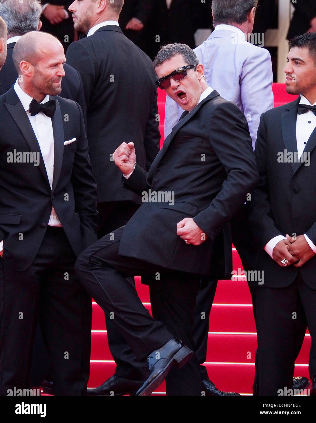 Antonio Banderas, kicks his leg up while Jason Stratham, left, and Victor Ortiz look on the red carpet at the Cannes Film Festival on May 18, 2014, in Cannes, France.  Photo by Francis Specker Stock Photo