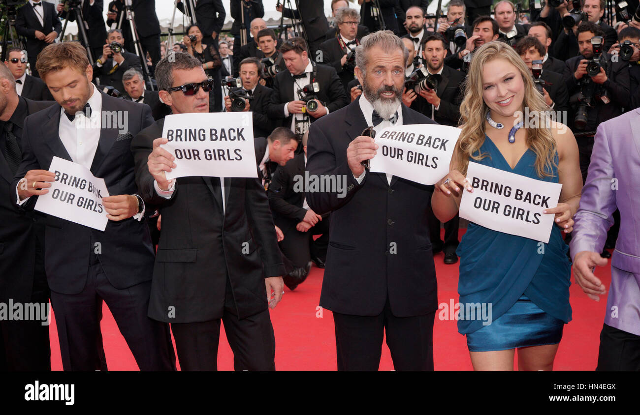 The cast of Expendables 3, Kellan Lutz, Antonio Banderas, Mel Gibson, and  Ronda Rousey hold up Bring Back Our Girls signs  on the red carpet at the Cannes Film Festival on May 18, 2014, in Cannes, France.  Photo by Francis Specker Stock Photo