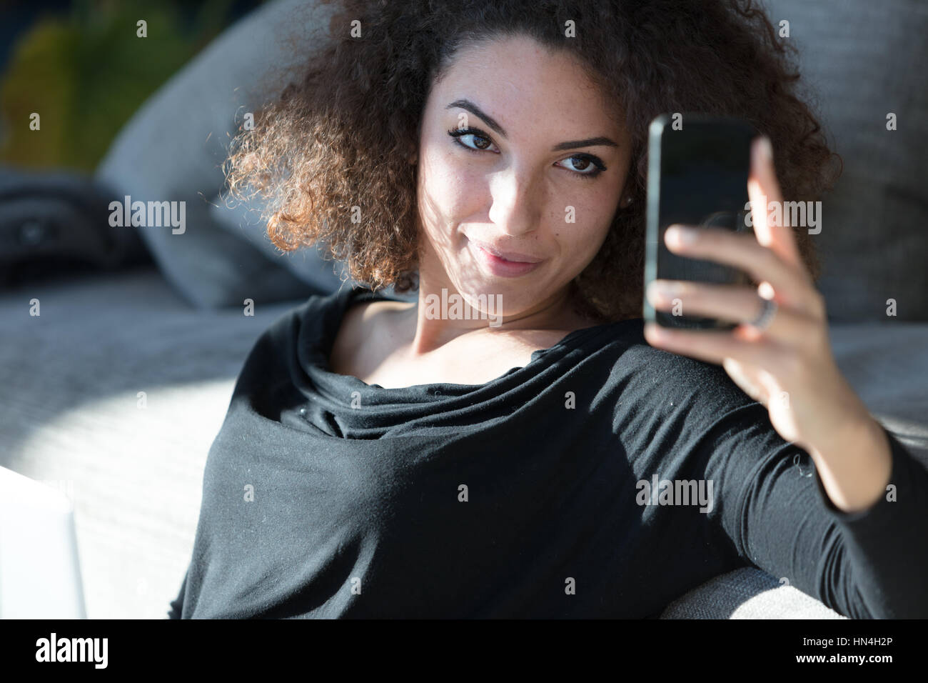 Natural relaxed attractive young woman taking her selfie on a ...