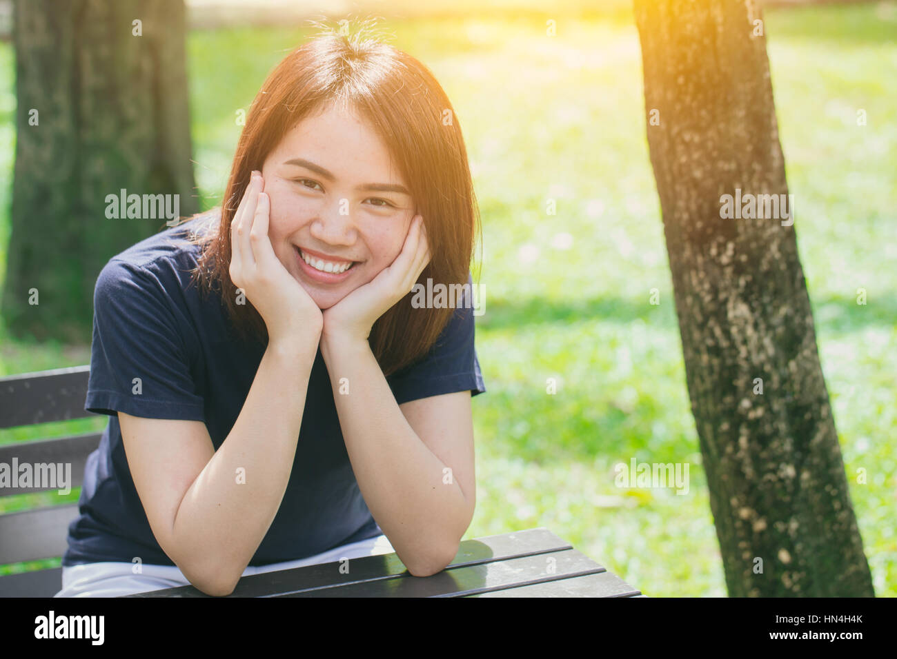 Single asian women teen cute short hair friendly smiley in the green park relax and smile. Stock Photo