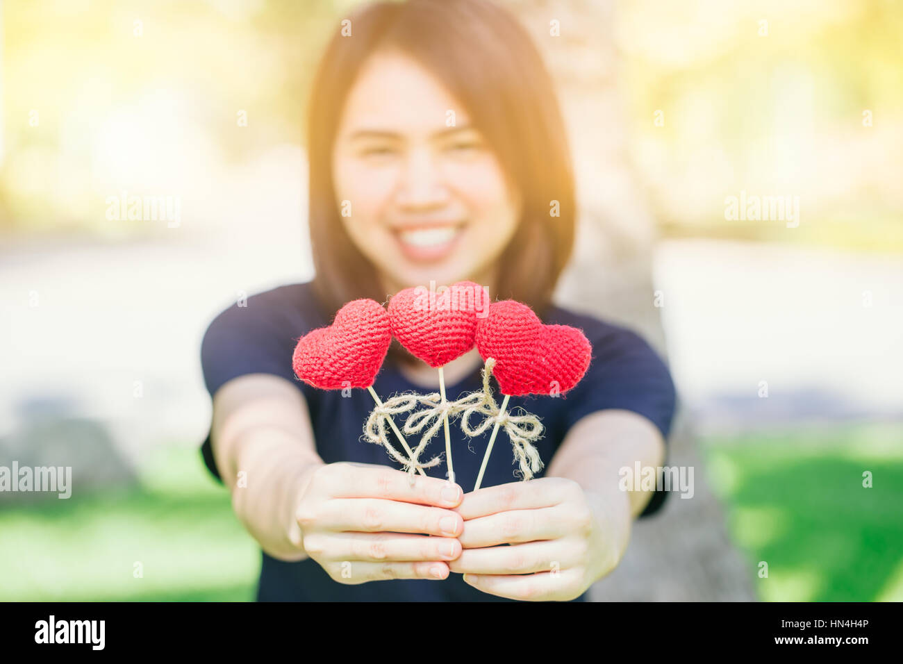 new friend love meeting and date cute smile Asian Thai teen hand hold red heart sweet loving symbol of take care or charity help to you. Stock Photo