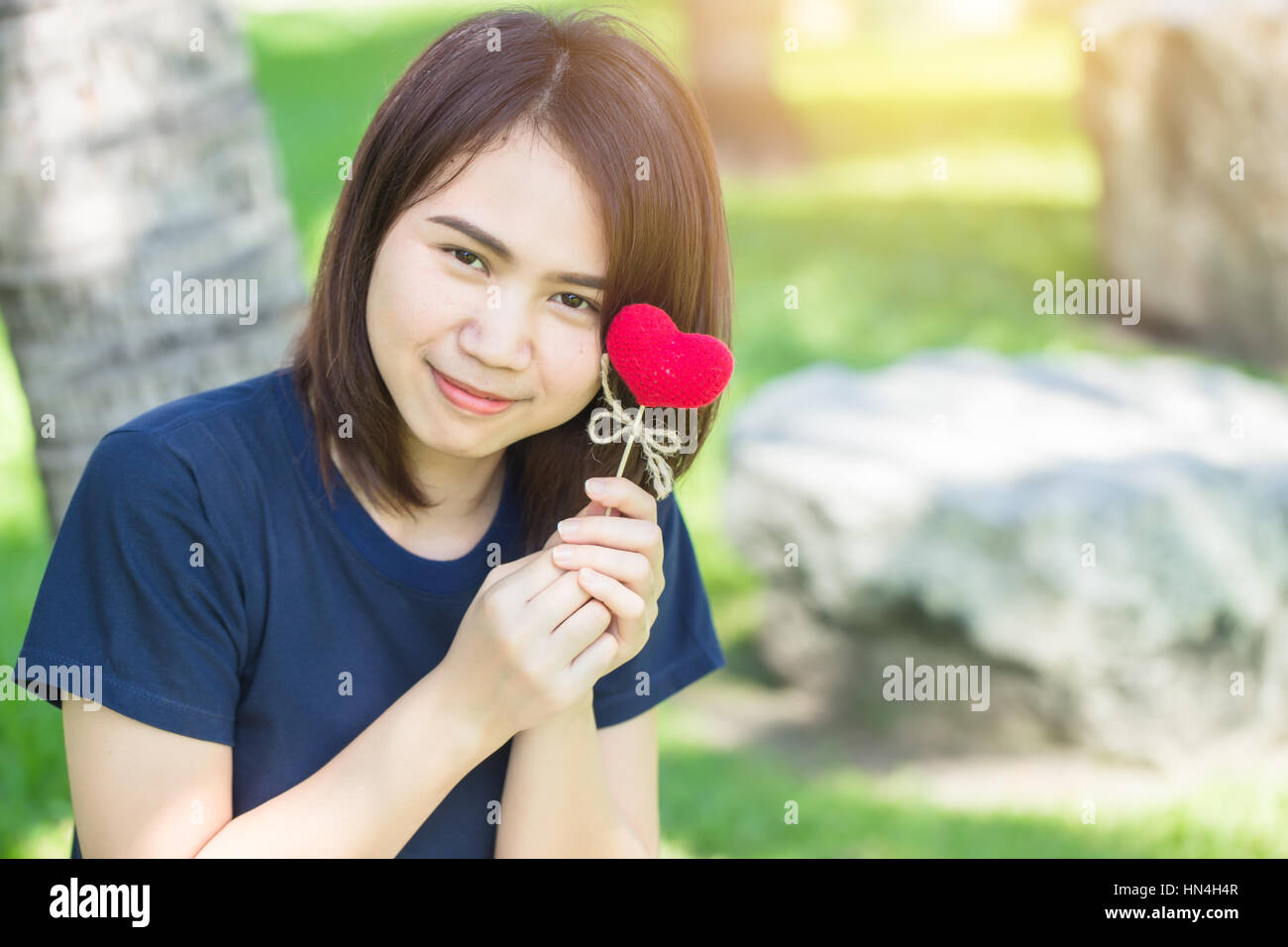 new friend love meeting and date cute smile Asian Thai teen hand hold red heart sweet loving symbol of take care or charity help to you. Stock Photo