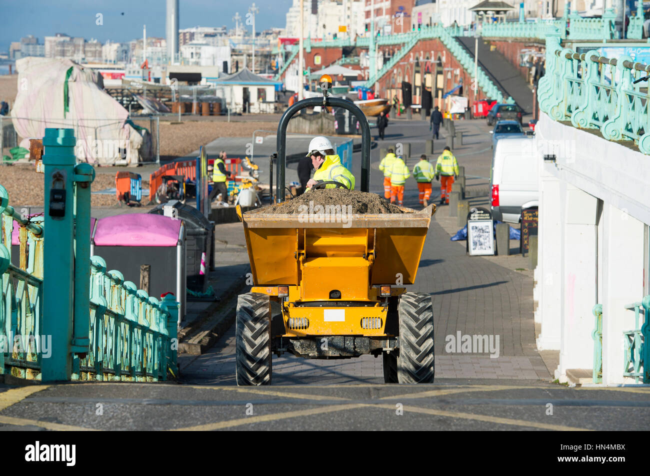 Construction site worker driving a dumper truck on Brighton seafront UK Stock Photo