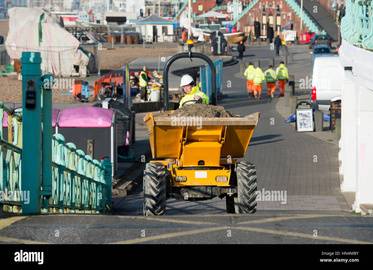Construction site worker driving a dumper truck on Brighton seafront UK Stock Photo