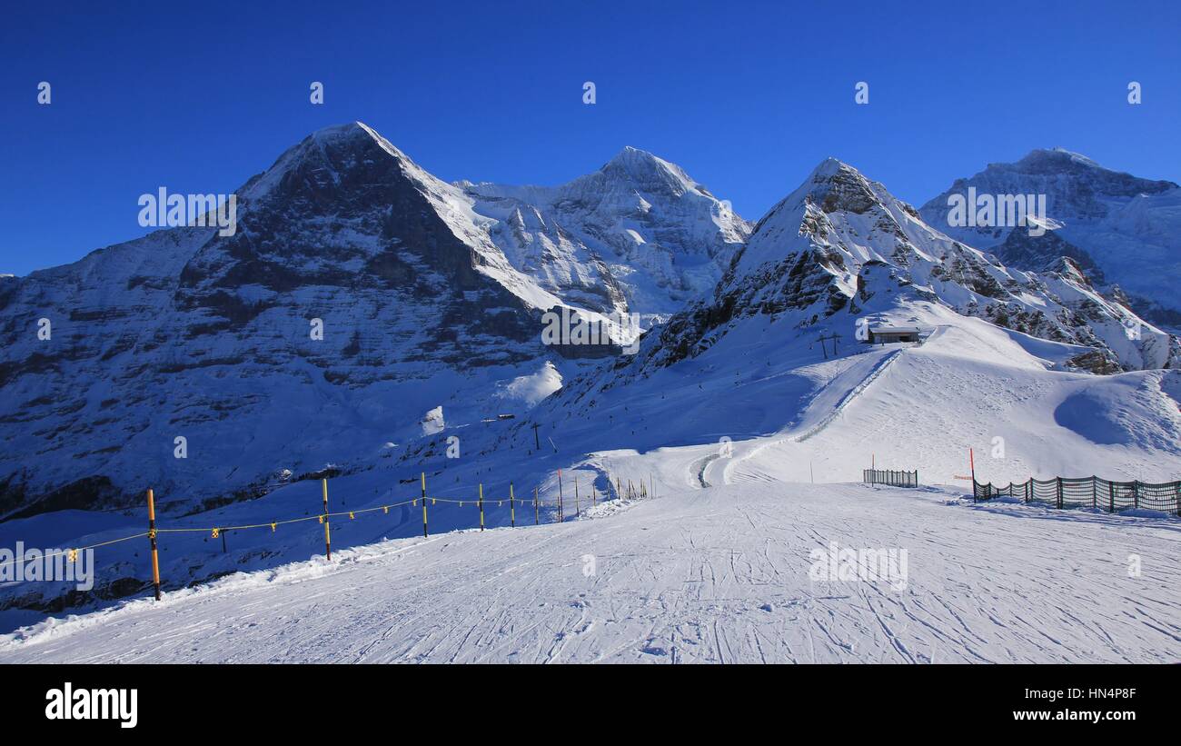 Winter scene in Grindelwald. Ski slope and snow covered mountaind Eiger, Monch, Lauberhorn and