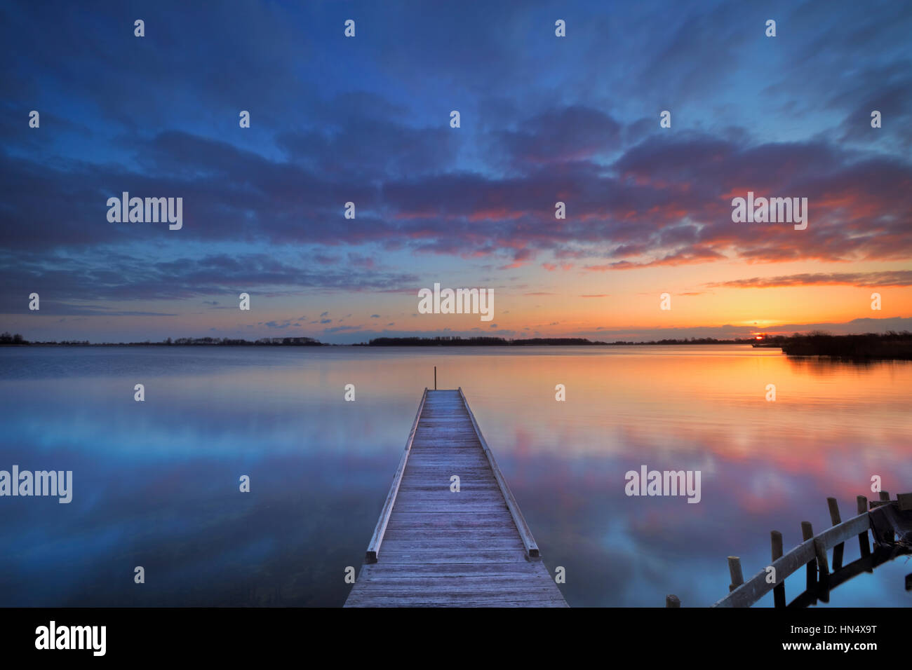 A small jetty on a lake at sunrise. Photographed near Amsterdam in The Netherlands. Stock Photo