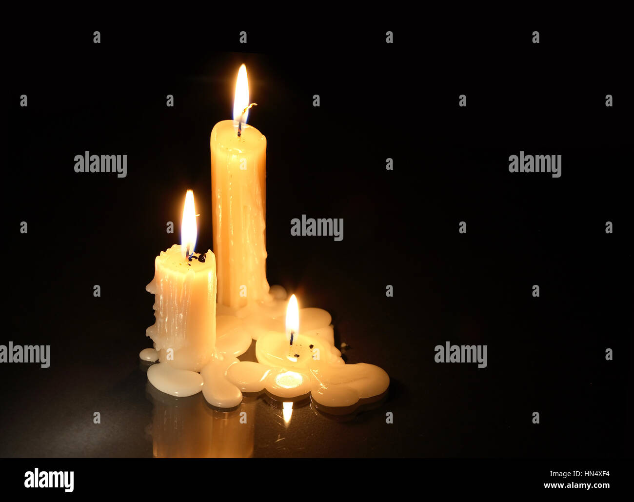 Three lighting candles on dark background with free space for text ...