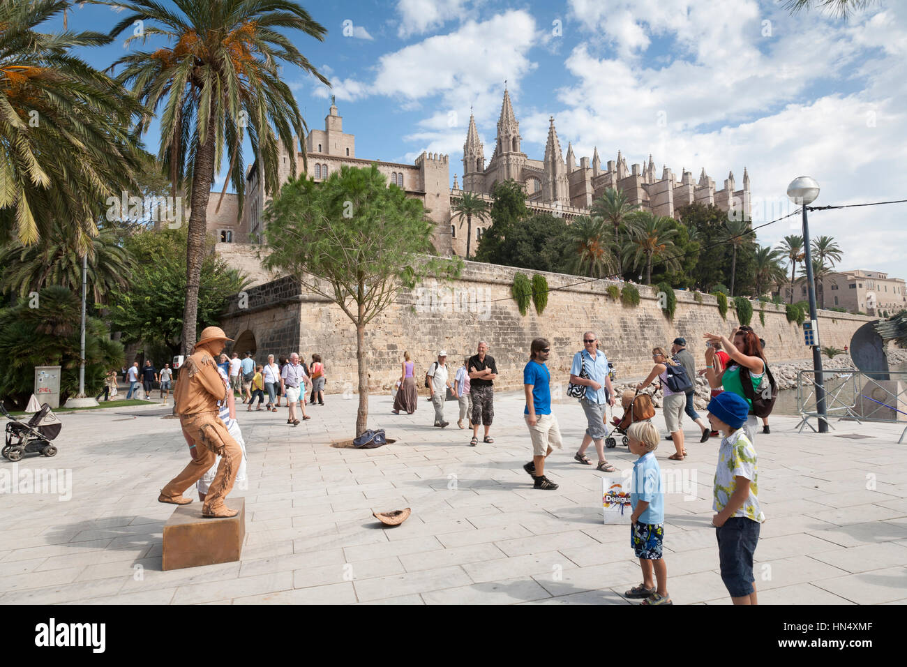 PALMA DE MALLORCA, SPAIN - OCTOBER, 9 : Street performer and passing tourists on the pedestrian area outside the Almudaina Palace and Cathedral in Pal Stock Photo