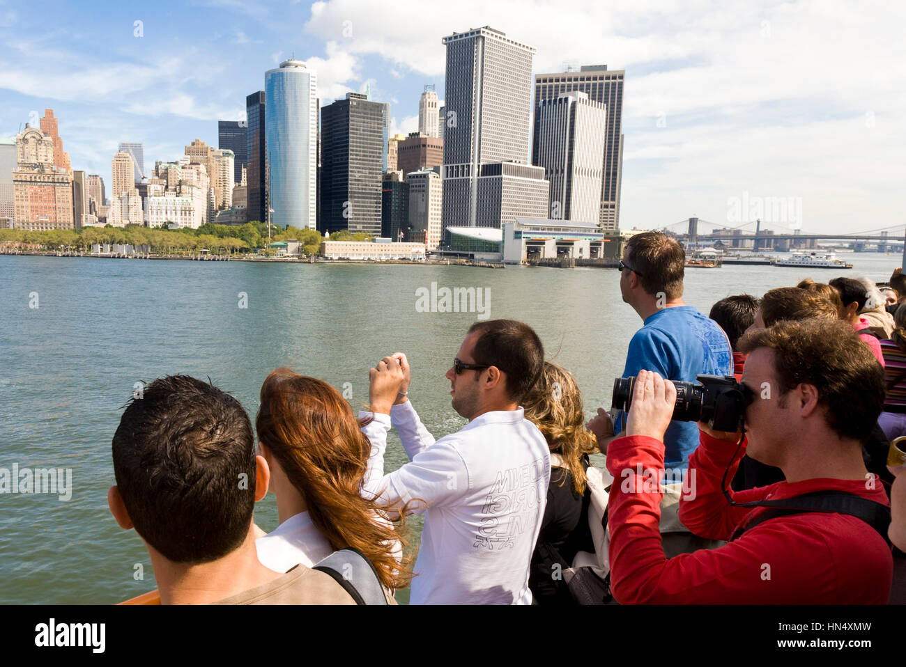 NEW YORK - SEPTEMBER 17 : Tourists on the Staten Island Ferry look out onto Battery park and the Downtown area of Manhattan, New York City on 17th Sep Stock Photo