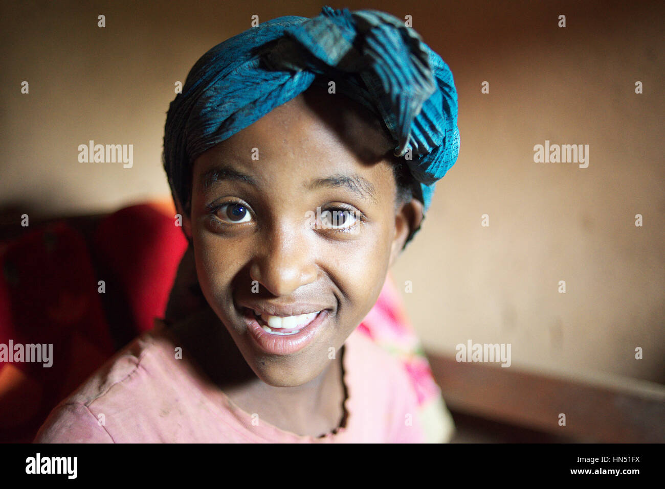 Portrait of attractive healthy young Ugandan girl smiling at the camera in her home in rural east africa Stock Photo