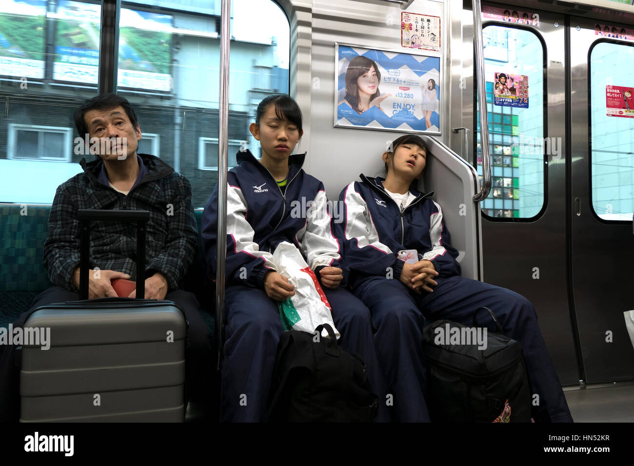 Asian people, Japanese girls, commuters napping while traveling on a local train in Tokyo, Japan, Asia. Railway, transportation Stock Photo