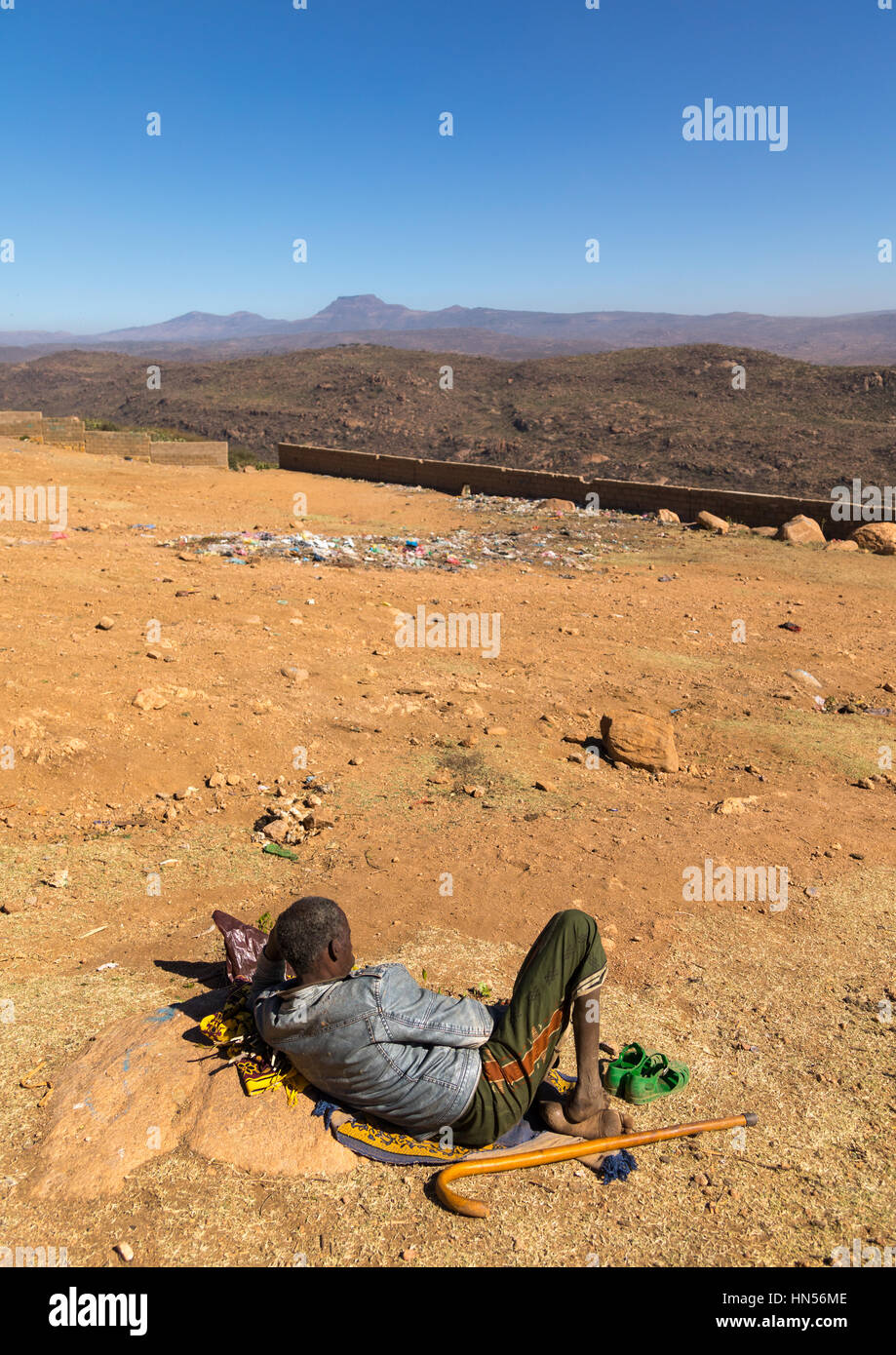 Ethiopian man chewing khat in front of a valley, Oromia, Babile, Ethiopia Stock Photo