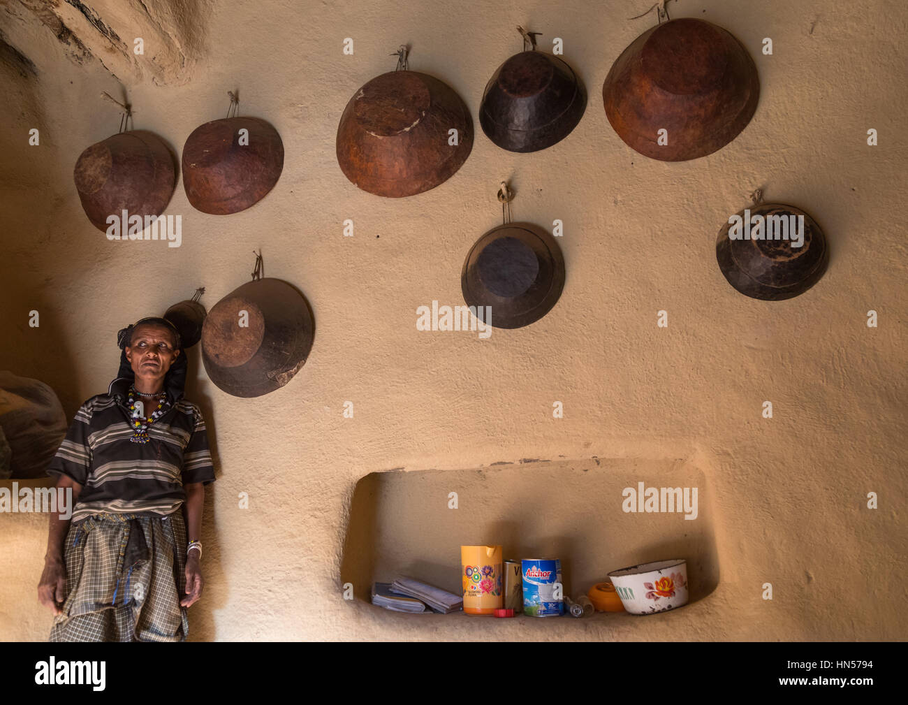 Woman inside her house decorated with leather baskets in a traditional Argoba stone houses village, Harari Region, Koremi, Ethiopia Stock Photo