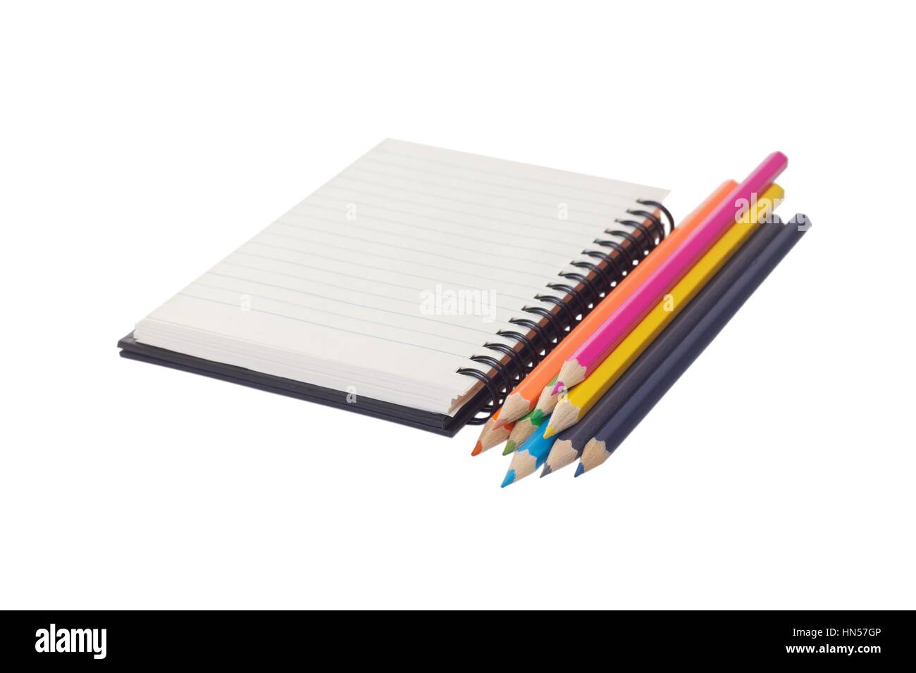 Close up of colour pencils and a notebook on isolated background Stock Photo