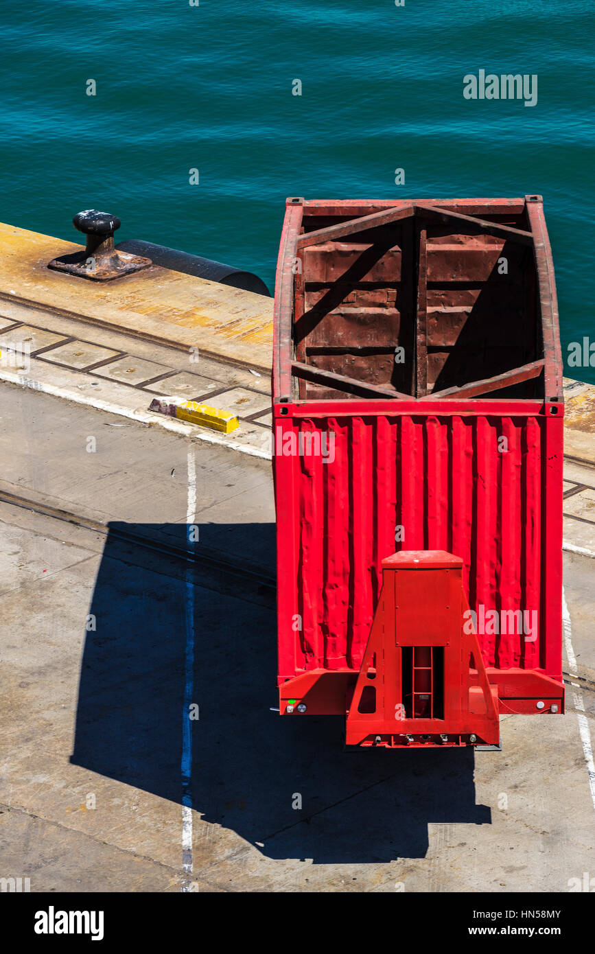 Empty red container waiting to board at the port of Barcelona, Catalonia, Spain Stock Photo