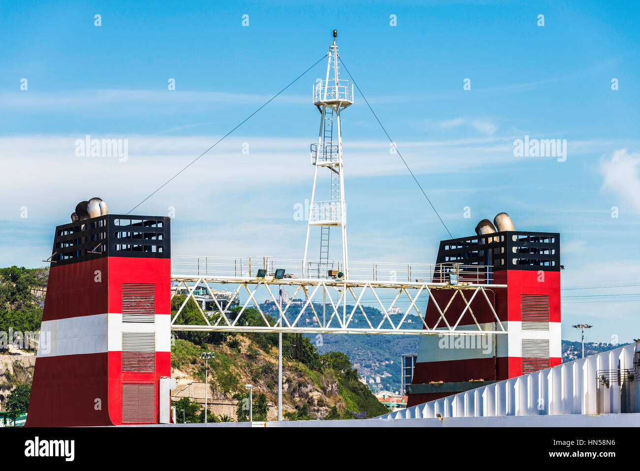 Red smokestack of a cargo ship with its look-out in the port of Barcelona, Catalonia, Spain Stock Photo