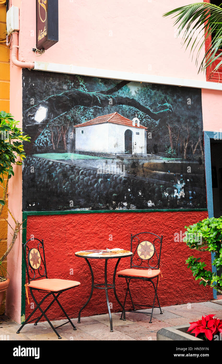 table and chairs at cafe restaurant with muralSan Sebastian, La Gomera, Canary Islands Stock Photo