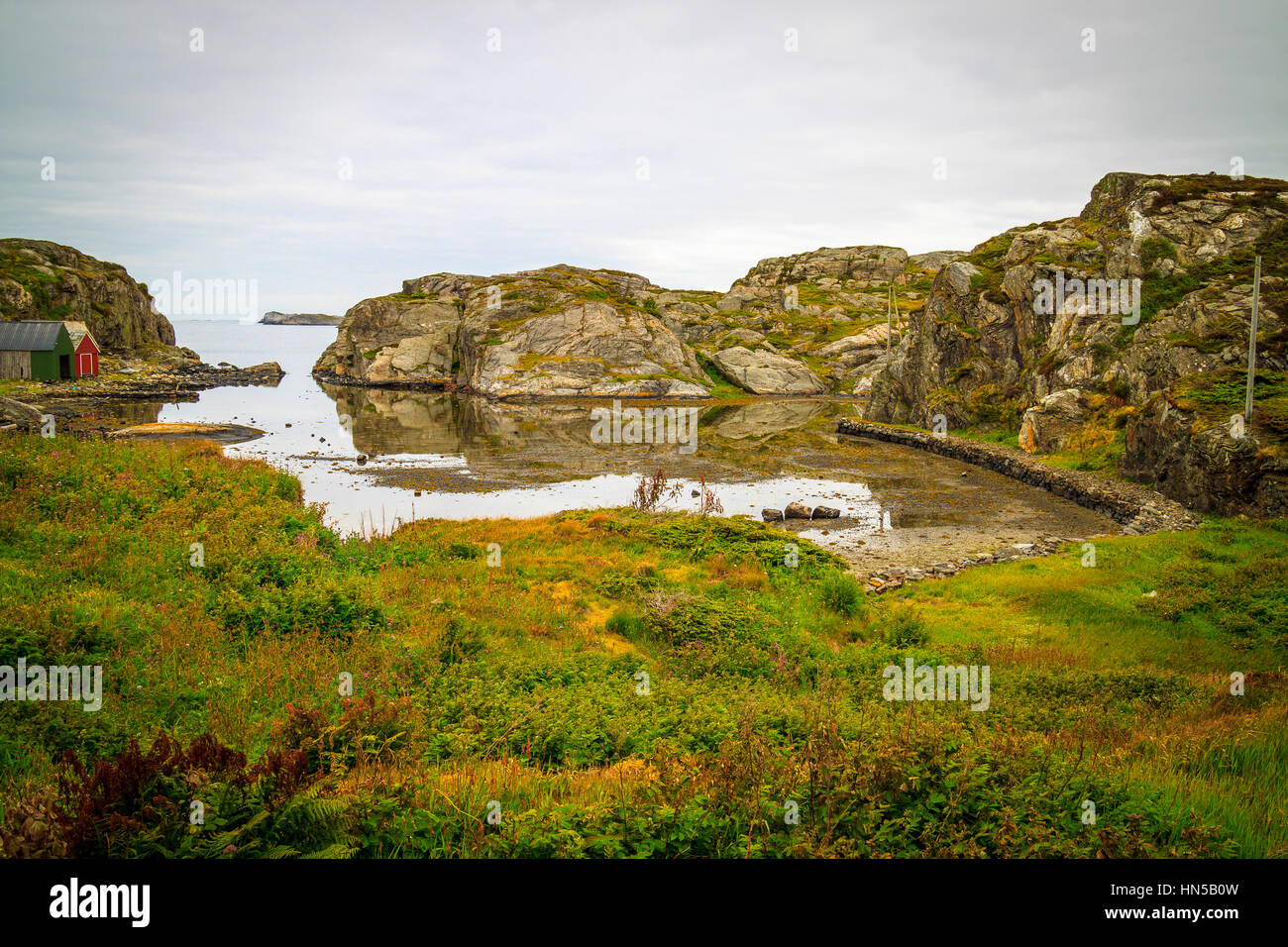 Coastal landscape, boat houses next to natural safe harbour when tide