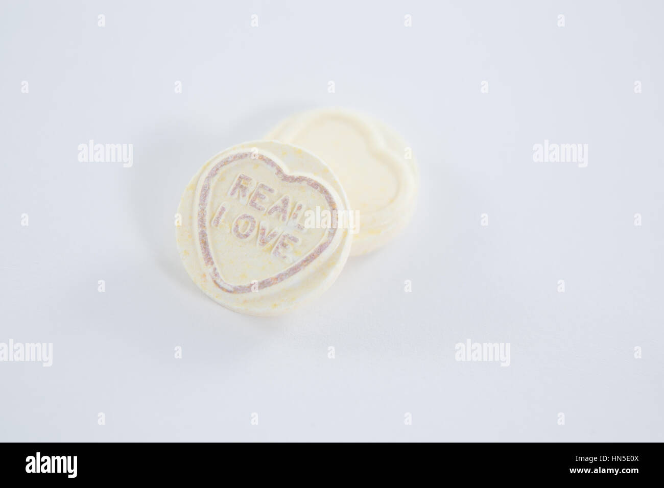 Heart shape confectionery with text real love on white background Stock Photo