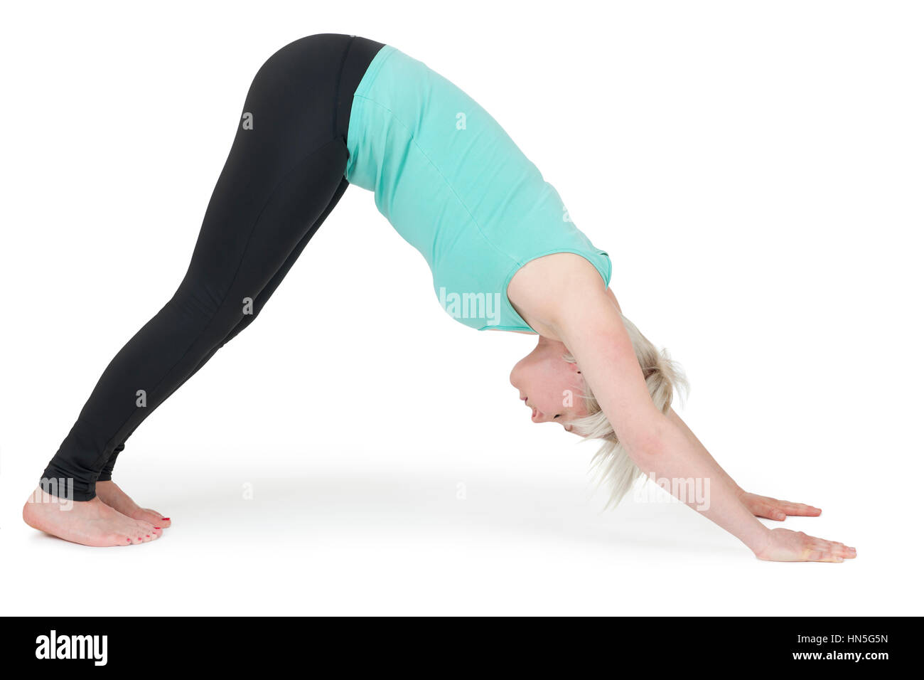 Ganzkörper-Ansicht einer jungen blonden Frau bei Yoga-Übungen vor weißen Hintergrund mit leichtem Schatten Stock Photo