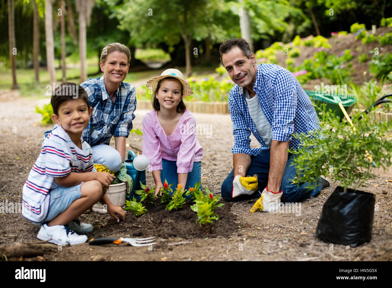 Portrait of happy family gardening together in garden Stock Photo - Alamy