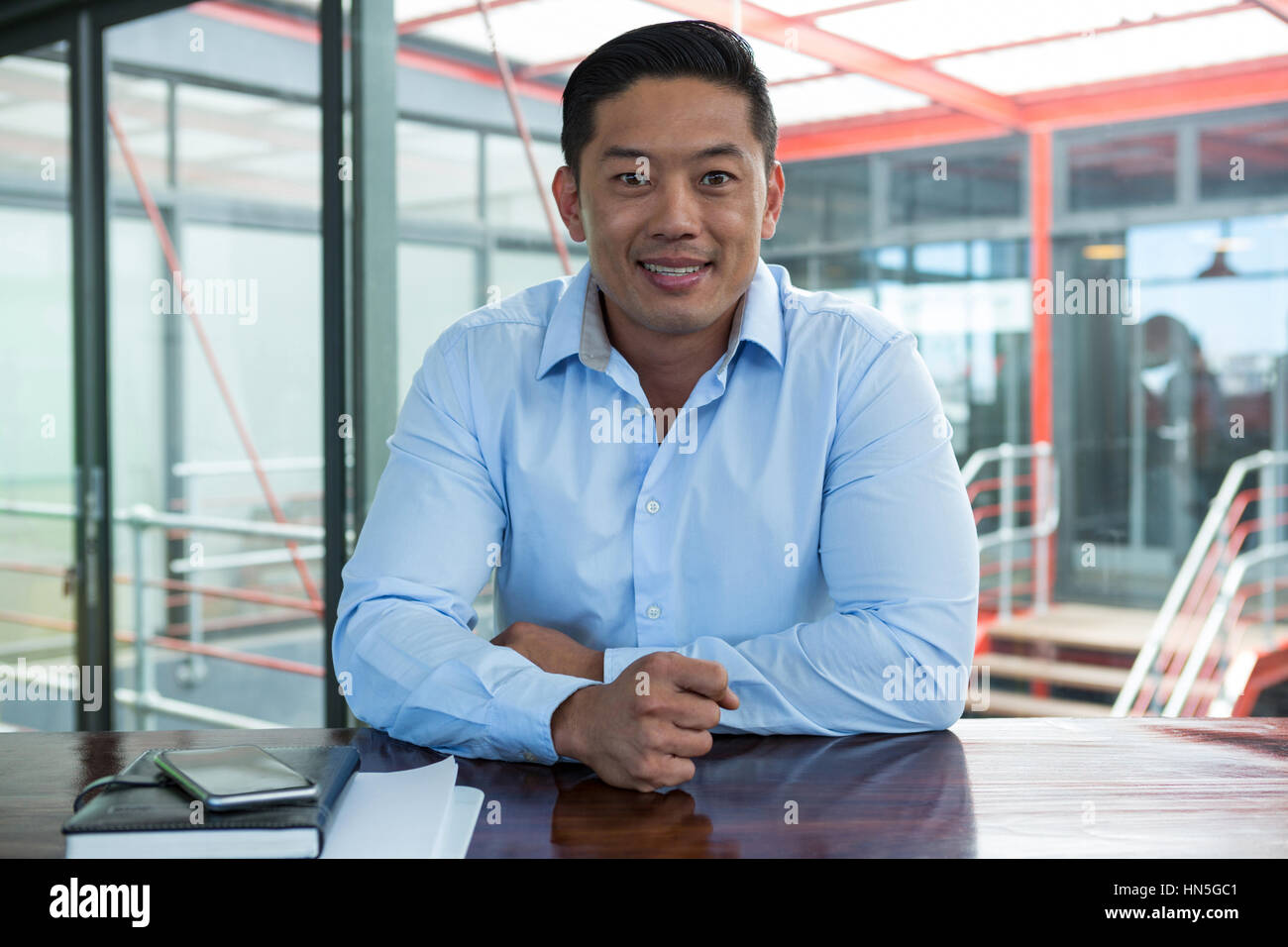Portrait of smiling businessman in office Stock Photo - Alamy