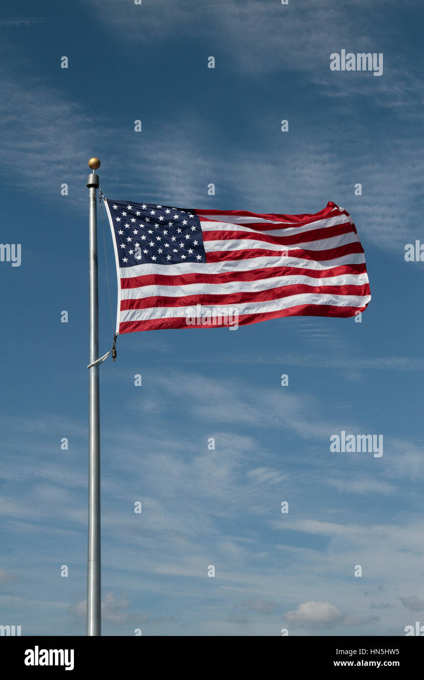 The Star Spangled Banner flying against a blue sky background. Stock Photo