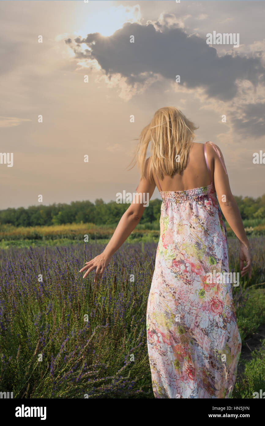 Girl in colorful dress walking through a lavender field at sunset Stock ...