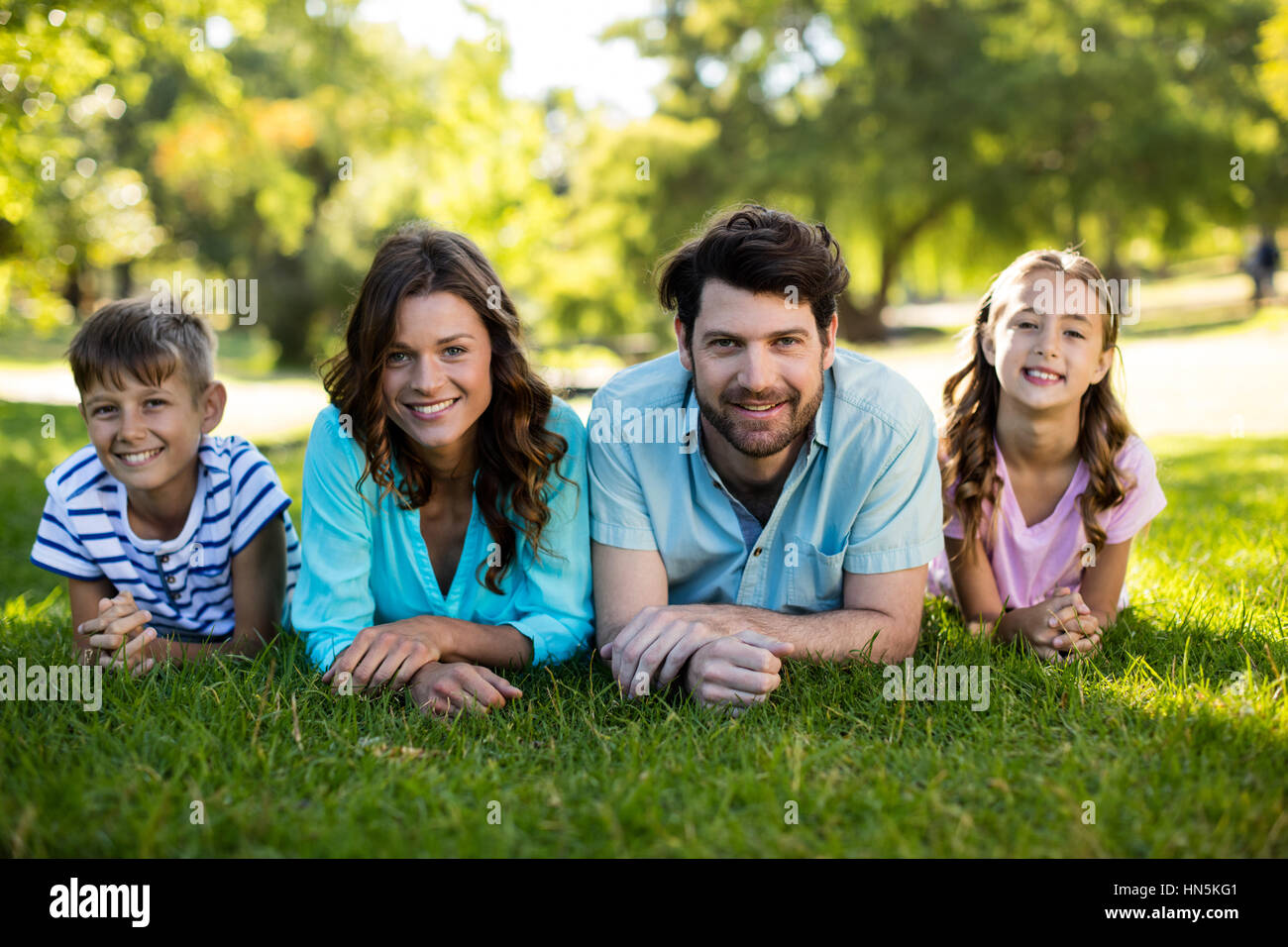 Portrait of happy family lying on grass in park on a sunny day Stock ...