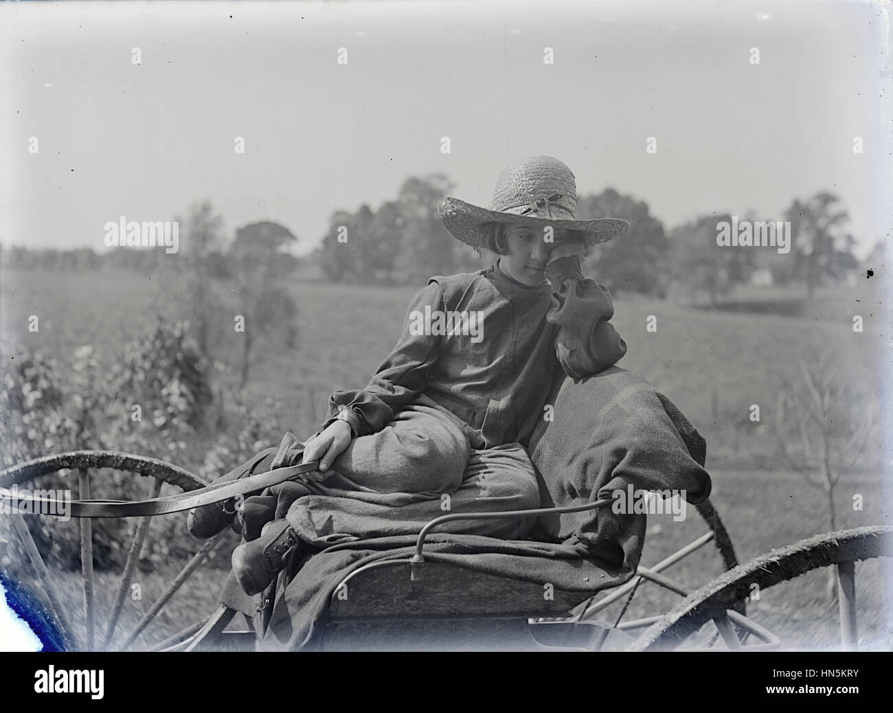 Antique c1900 photograph, young girl on a wagon holding reins. Location unknown, possibly Jamestown, New York, USA. Stock Photo