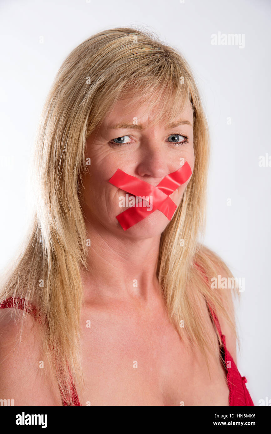 Woman with red tape strtched across her mouth Stock Photo