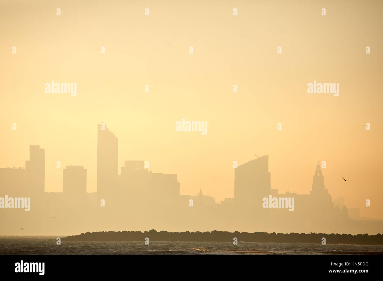 Liverpool bay golden sunrise from New Brighton beach in Wallasey, Merseyside, Wirral, England, UK looking out to see over the city centre waterfront s Stock Photo