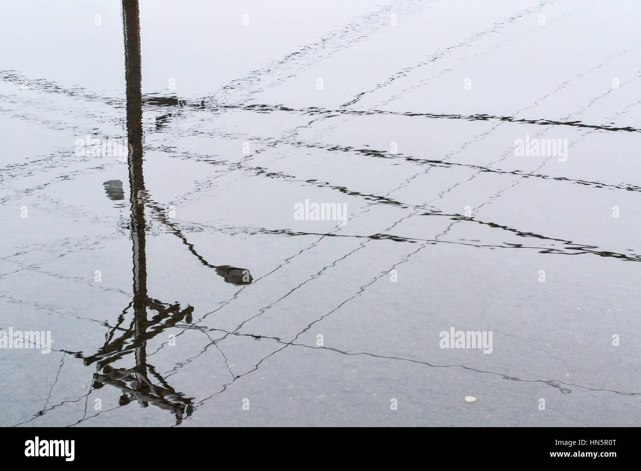 Reflection of power line in a puddle Stock Photo