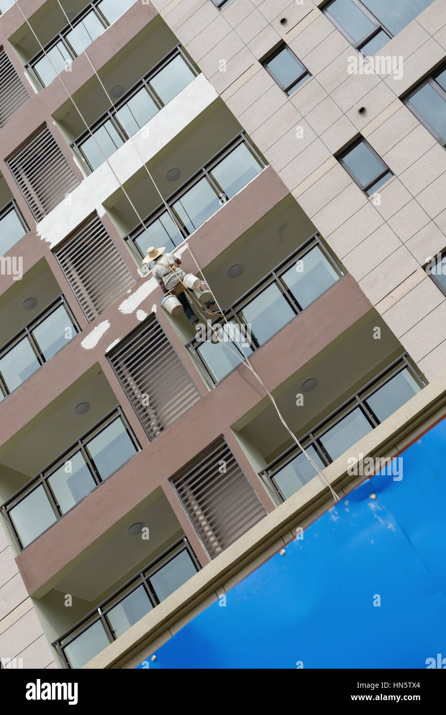 worker repairing the outside of a tall building Stock Photo - Alamy