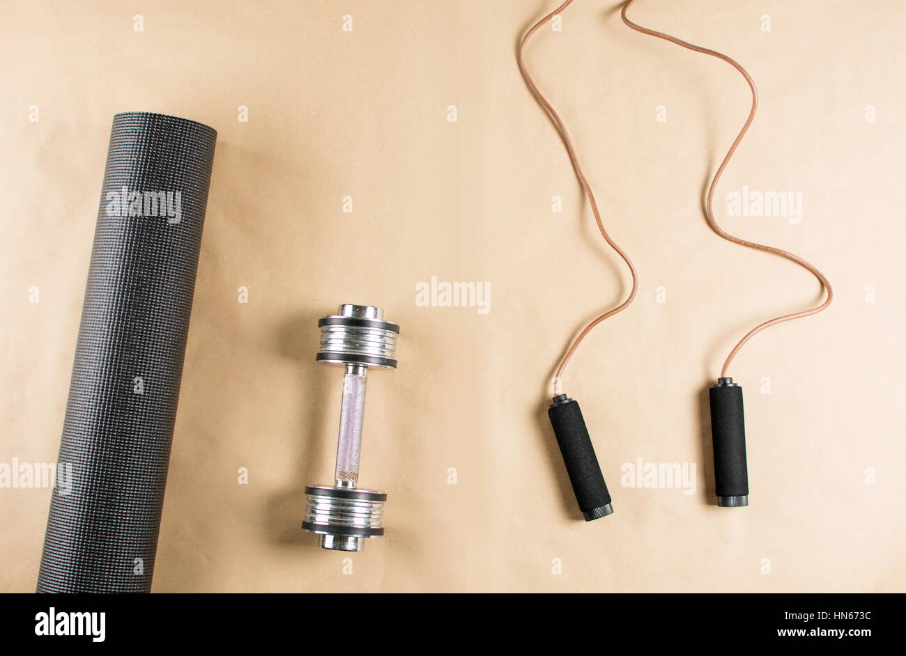 Yoga mat with dumbbell and leather jumping rope Stock Photo Alamy